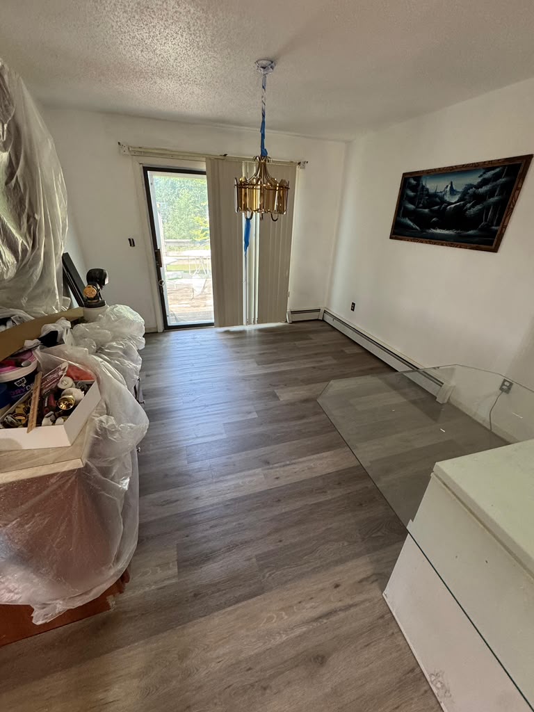 Laminate flooring installed in a dining room with patio doors