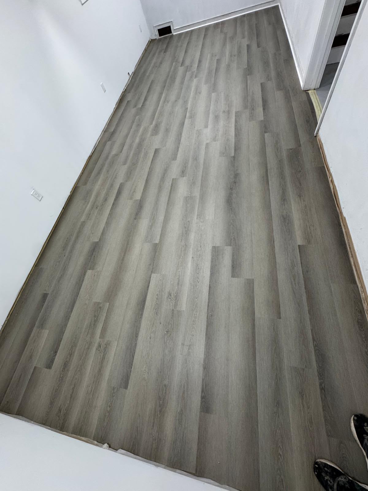 Grey vinyl plank flooring installed in a finished room