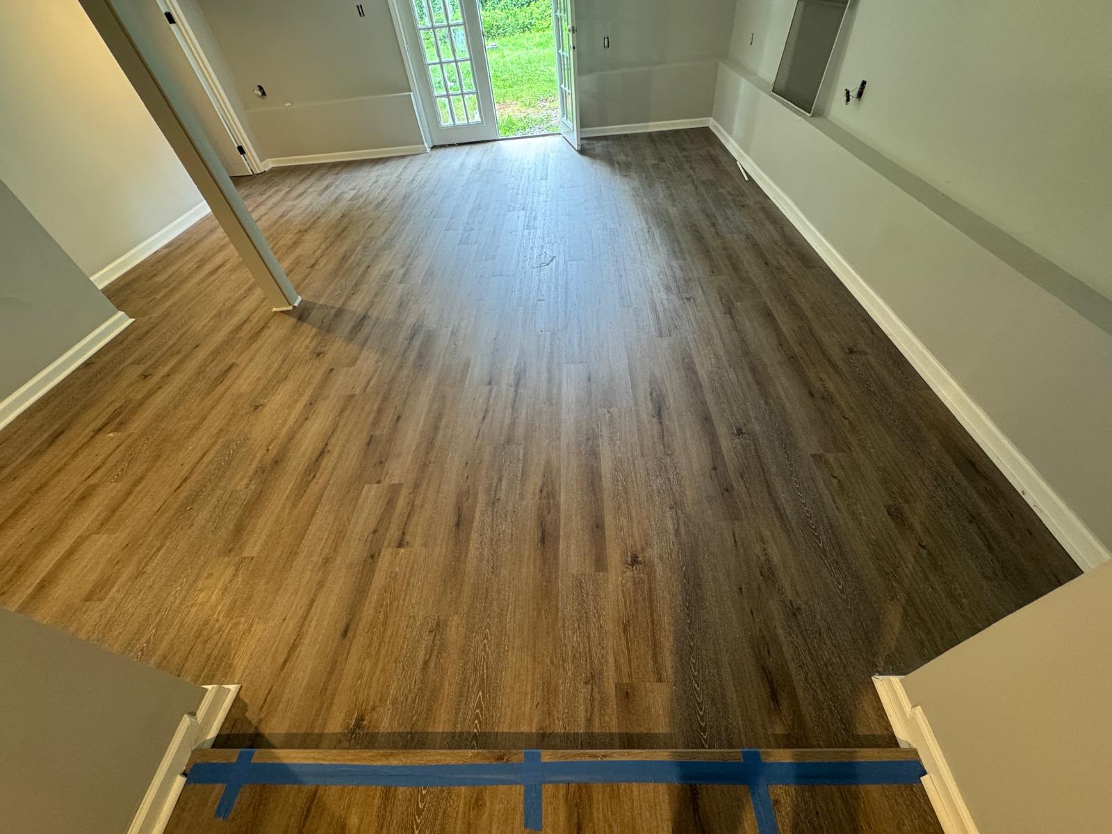 Laminate flooring installed in a living room with french doors