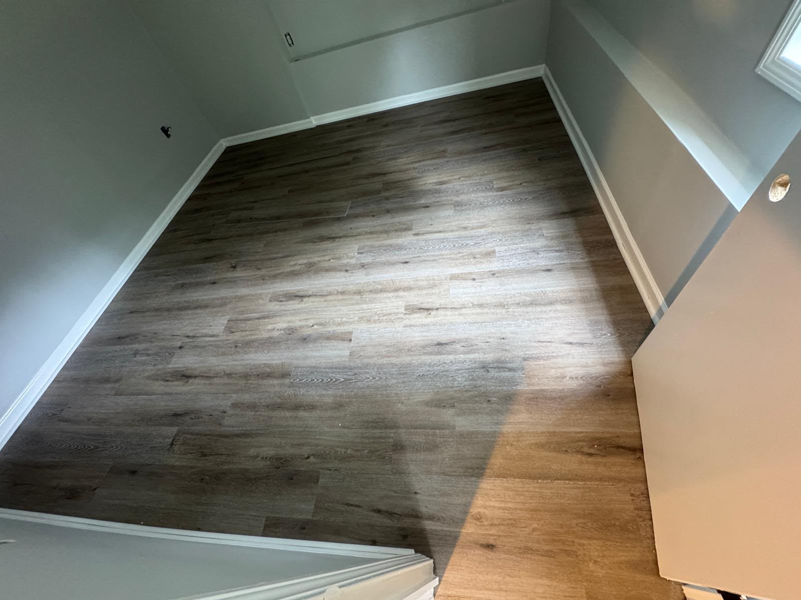 Grey laminate plank flooring installed in a bedroom