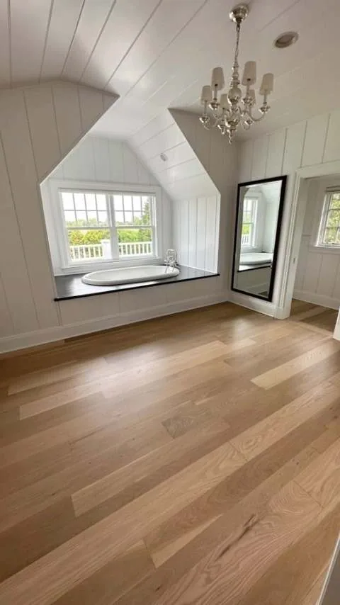 Light oak floor in an attic bedroom with a window seat