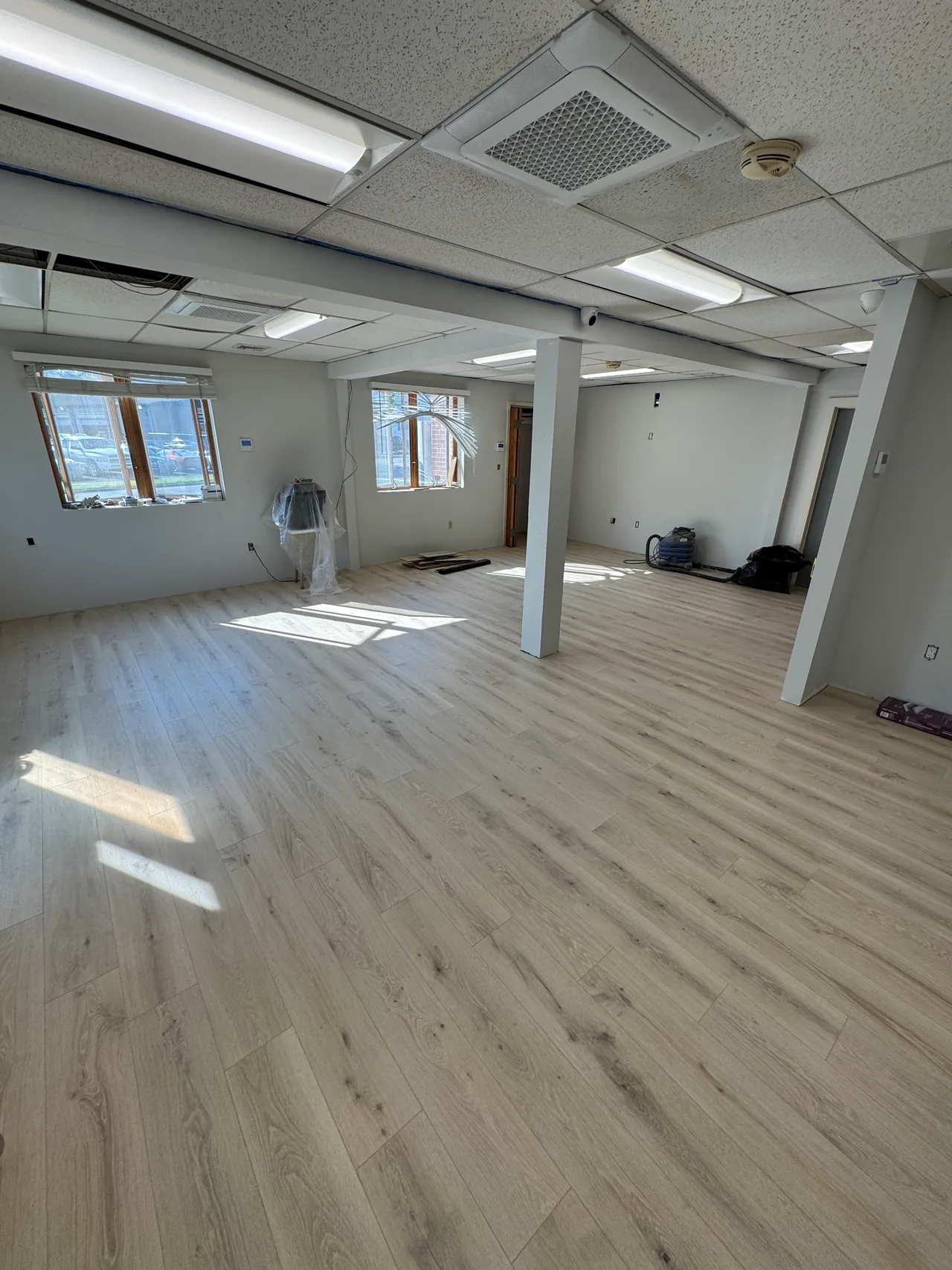 Gray laminate flooring installed in a large basement