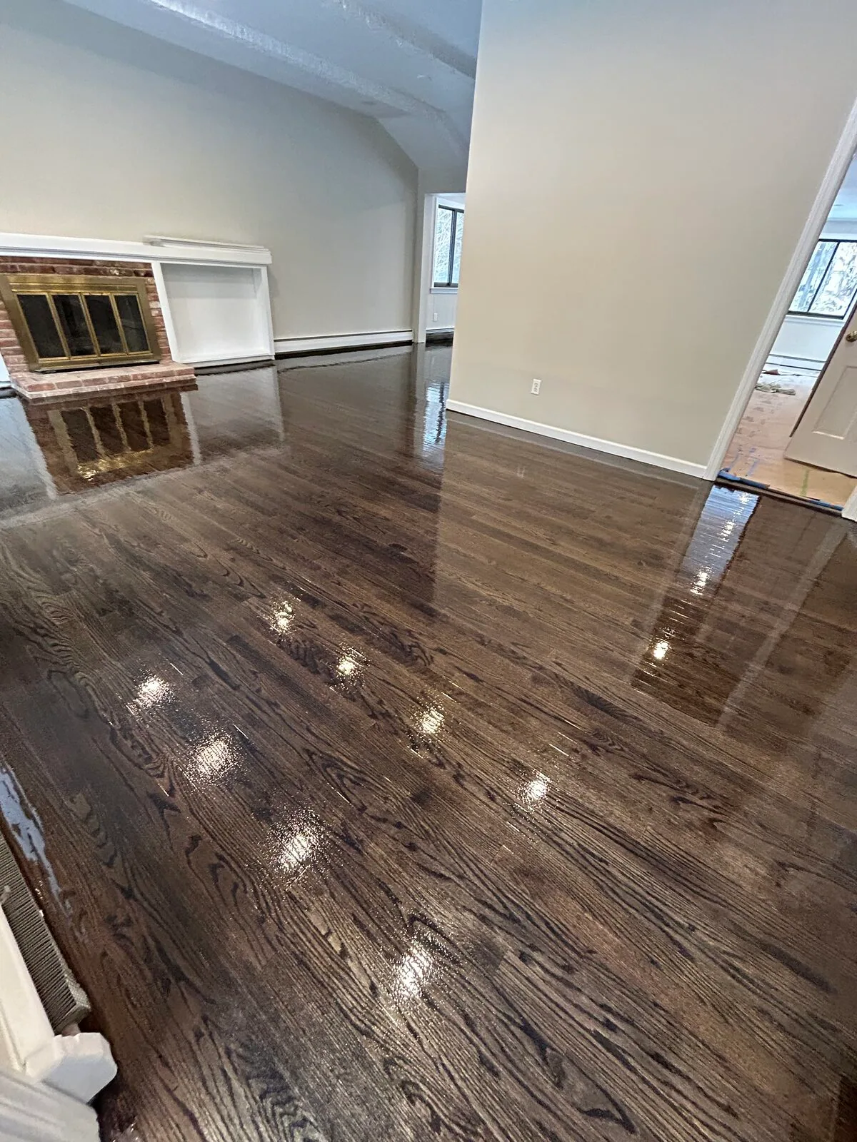 Dark gray-brown stained hardwood with a gloss finish in an open room