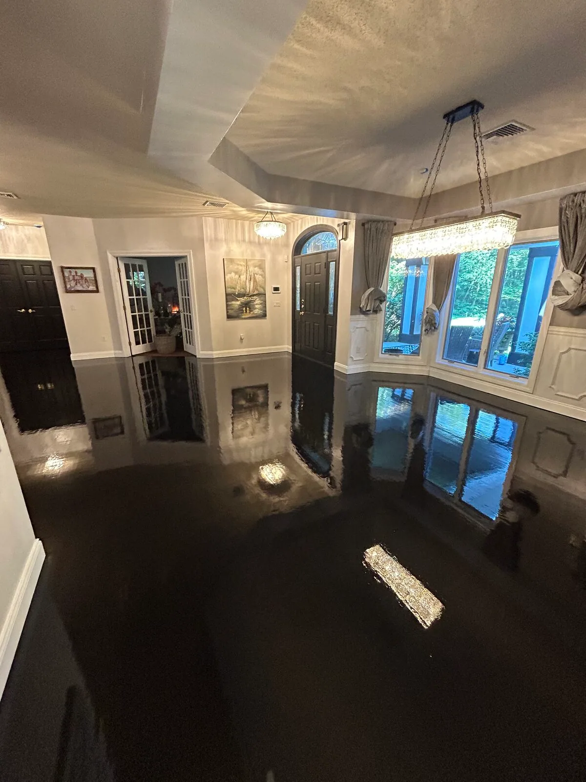 High-gloss ebony floor under a chandelier