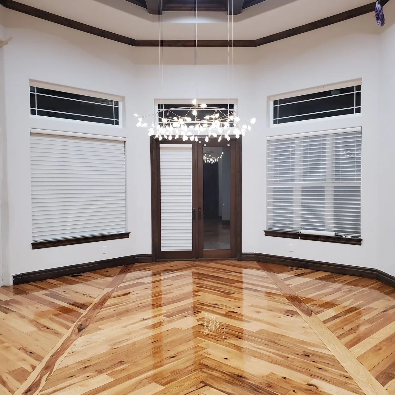 Glossy hardwood with a herringbone center and a dark border