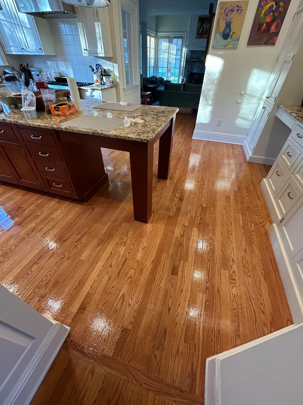 Red oak floor refinished with a gloss finish around a kitchen island