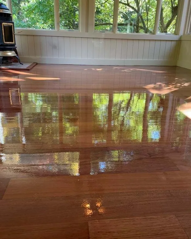 High-gloss floor reflecting a sunroom's windows